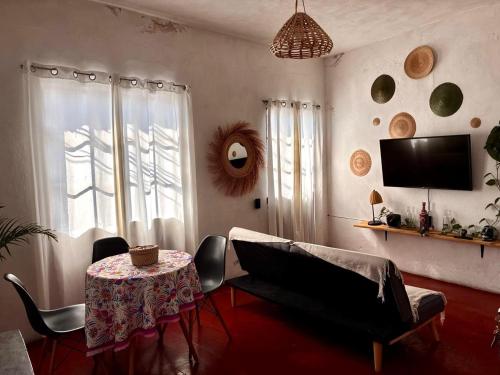 a living room with a table and a tv at Casa Roma in Taxco de Alarcón
