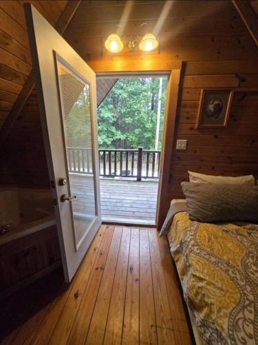 a bedroom with a bed and a door to a deck at Mountain Memories - RRG in Rogers