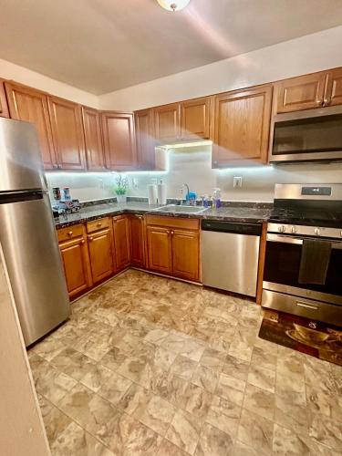 a kitchen with wooden cabinets and stainless steel appliances at 3BR W/ BASEMENT HOME 'THE LION’S DEN' in Temple Hills