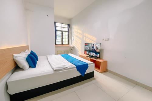 a bedroom with a bed and a tv in it at Staigo at SG Premium in Medan