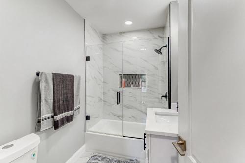 a white bathroom with a shower and a sink at Group-Friendly Michigan City Home Near Beach! in Michigan City