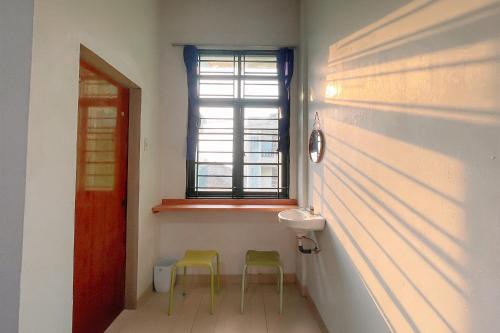 a bathroom with two stools and a sink and a window at Staigo at SG Premium in Medan