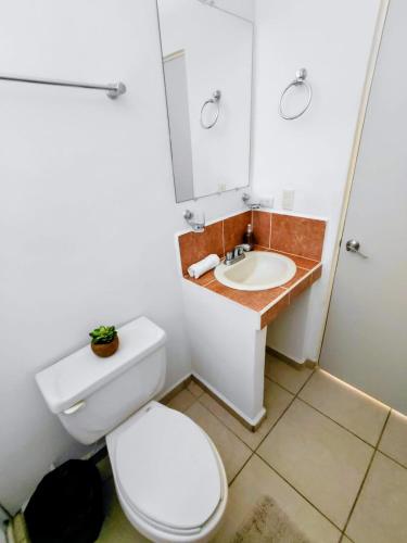 a bathroom with a toilet and a sink at Residencia en Privada con Casa Club y Alberca in La Paz