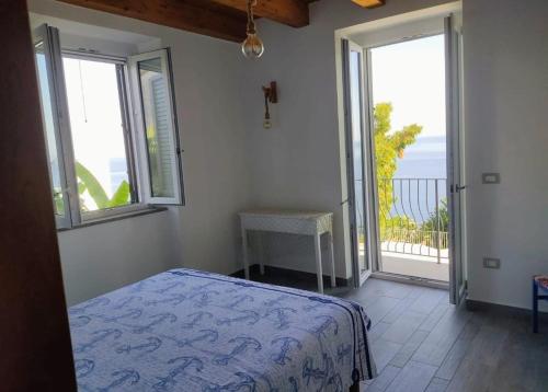 a bedroom with a bed and two windows and a balcony at La Perla di Buffari Appartamento Ciappina in Palmi