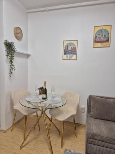 a dining room with a glass table and two chairs at ZenCozy Studio - Free Underground Parking in Bucharest