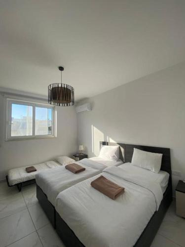 two large beds in a room with a window at Marija Block St Julian's Apartments in Is-Swieqi