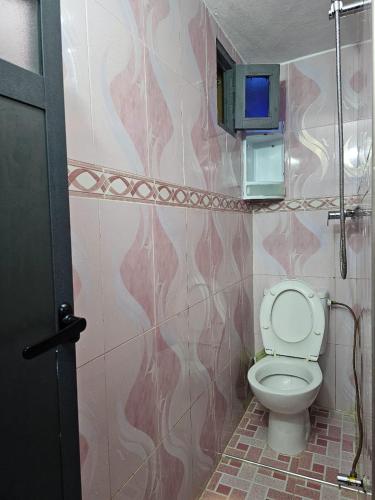 a bathroom with a toilet and a wall at ADAGHAS studio 1,3 in Agadir