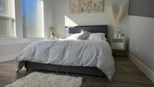 a bedroom with a large bed in a white room at Modern Coastal 2BR Retreat with Private Hot Tub in Vancouver BC in West Vancouver