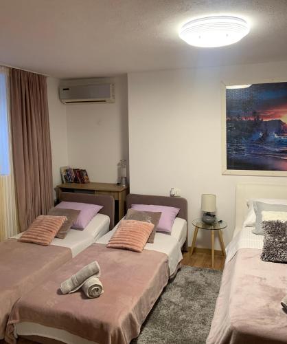 a room with three beds and a painting on the wall at Sweet Cosy Apartment in Matulji