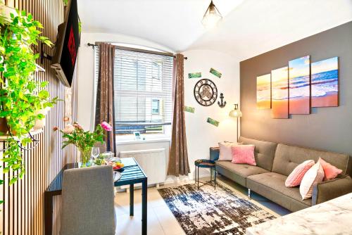 a living room with a couch and a table at Stylish 1-Bedroom Apartment near Beach - Brighton in Brighton & Hove