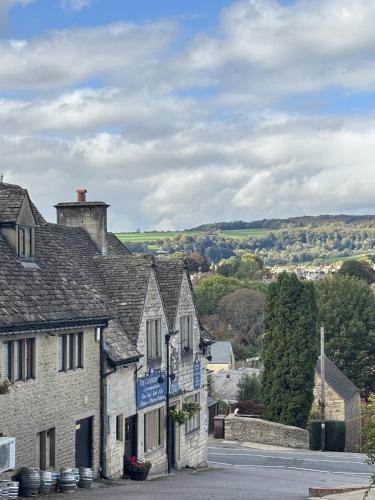 an old stone building in a village with a street at The Clothiers Arms in Stroud