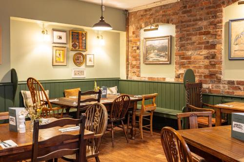 a dining room with wooden tables and chairs at The Clothiers Arms in Stroud