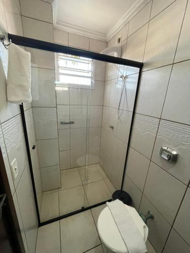 a bathroom with a toilet and a glass shower at Hotel Germânia Nova Veneza in Nova Veneza