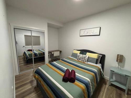a bedroom with a bed with a pair of shoes on it at Fowler Road Cozy Lower Suite in Airdrie