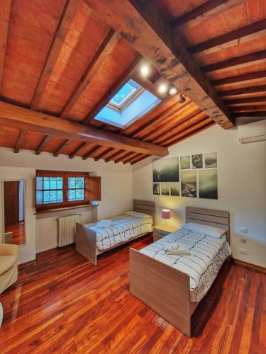 two beds in a large room with wooden ceilings at Villa Castaldi Firenze vicina al centro in Florence