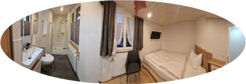 a small room with a bathroom with a bed and a sink at Mirchel Pintli, Zimmer 2, Hotel & Restaurant in Zäziwil