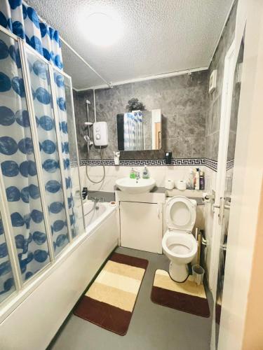 a small bathroom with a toilet and a sink at Oakley Court Room in Wallington