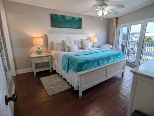 a bedroom with a bed with a blue comforter at Gulf Balcony - Boutique Comforts & 2 King Suites in Fort Walton Beach