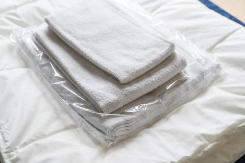 four towels in a plastic container on a bed at Appartement De Bosrand, Resort Amelander Kaap in Hollum