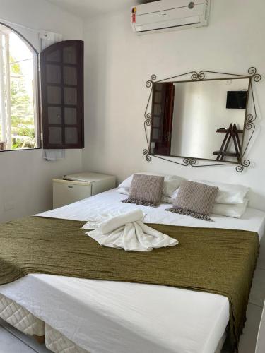 a bedroom with a bed with a mirror on the wall at Recanto do caja in Porto De Galinhas