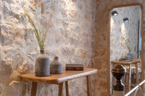 two vases sitting on a table next to a mirror at Paliokaliva Apartments and Villas in Tsilivi