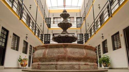 a large fountain in a building with stairs at Cinco de Mayo Hotel in Querétaro