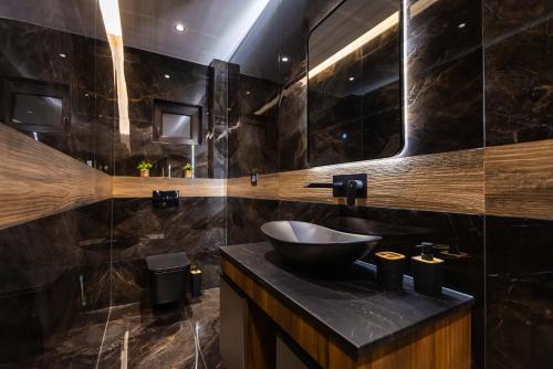 a bathroom with a sink and a mirror at Apartman ALPINA Bogatic in Bogatić
