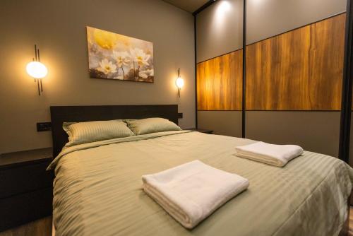a bedroom with a bed with two towels on it at Apartman ALPINA Bogatic in Bogatić