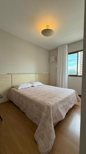 a bedroom with a large bed with a blanket on it at Charme e Conforto na Savassi in Belo Horizonte