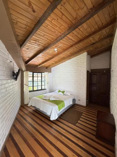 a bedroom with a bed and a wooden ceiling at Hostería Agoyan Deluxe in Ulba