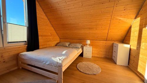 a bedroom with a bed in a wooden cabin at Cud Miód Mazury in Bogaczewo