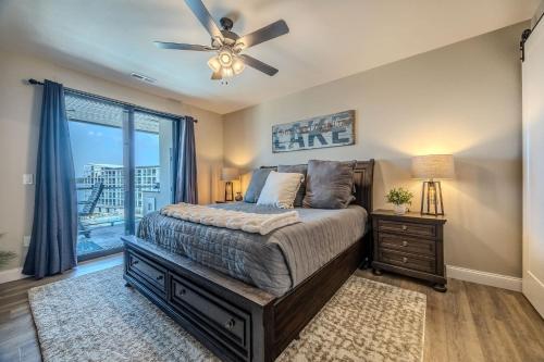 a bedroom with a bed with a ceiling fan and a window at Family Tides Condo for 8 in Osage Beach