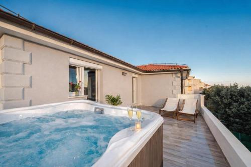 a hot tub on the balcony of a house at LUXURY MANDRE HOUSE in Mandre