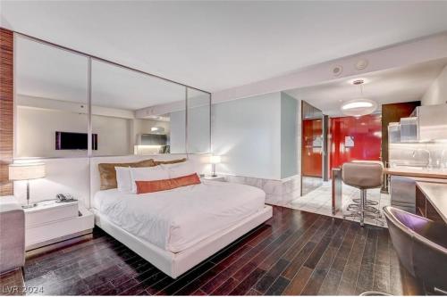 a bedroom with a large white bed with a glass wall at Palms Place in Las Vegas