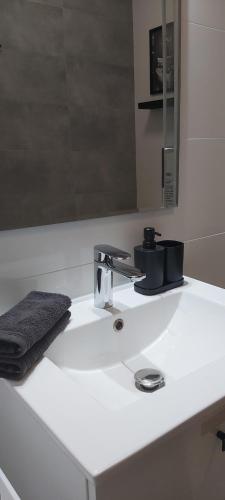 a bathroom sink with a black towel on it at Ambasada zieleni in Uniejow