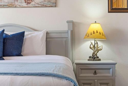 a lamp on a night stand next to a bed at Blue Sky Lodge For 4 in Branson West