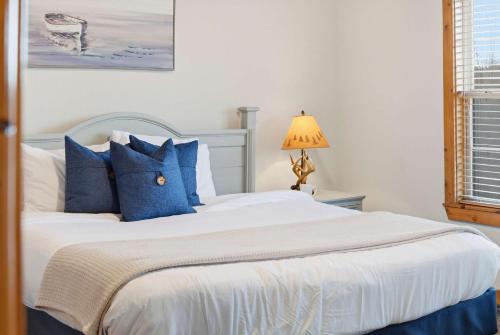 a bedroom with a large bed with blue pillows at Blue Sky Lodge For 4 in Branson West