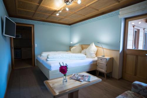 a bedroom with a bed and a table with flowers on it at Gasthaus Posch in Miesbach