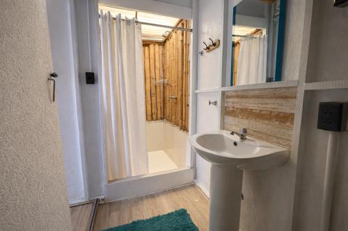 a bathroom with a sink and a shower and a mirror at Wild Rover Beach Mancora in Máncora