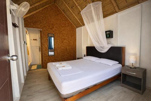 a bedroom with a white bed with a canopy at Wild Rover Beach Mancora in Máncora