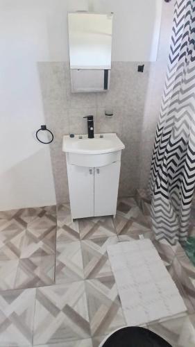 a bathroom with a white sink and a mirror at La Mejor-A in Comandante Luis Piedra Buena