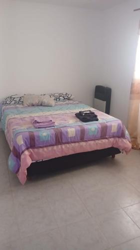 a bed with a blanket on top of it at La Mejor-A in Comandante Luis Piedra Buena