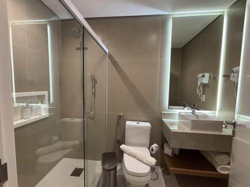 a bathroom with a shower and a toilet and a sink at Hotel Fazenda Brisa Itu in Itu