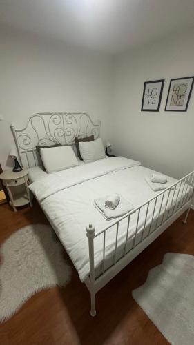 a bedroom with a white bed with white sheets and pillows at Apartman Staro Petrovo Selo in Staro Petrovo Selo