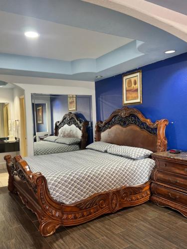 a bedroom with two beds and a blue wall at Raintree Inn and Suites in Houston