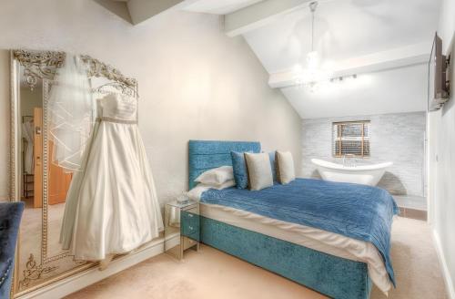 a bedroom with a blue bed and a sink at The George Wright Boutique Hotel, Bar & Restaurant in Rotherham