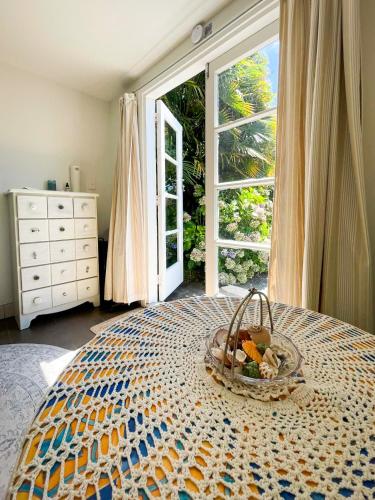 a basket of fruit on a bed with a window at Ruby Bay Beach Sleepout - 30 mins from Abel Tasman in Mapua