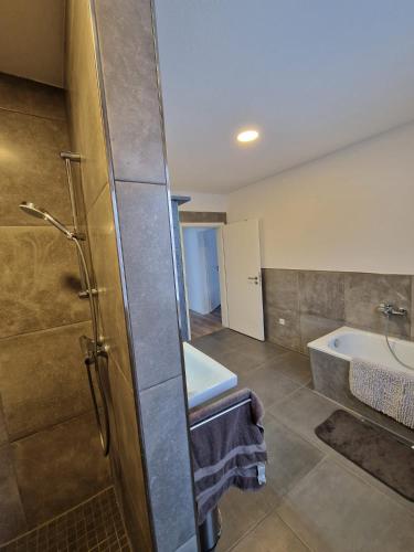 a bathroom with a shower and a sink and a tub at Monteurwohnung RoomWork24 - 10 Betten - Twistringen in Twistringen