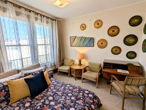 a bedroom with a bed and a desk and some windows at Perfect Location - 4BD,1BA - Restored Redwood Home in San Francisco