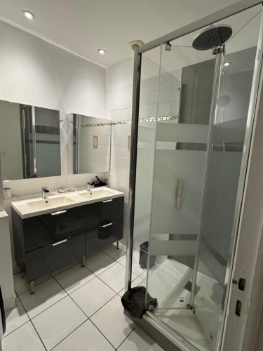 a bathroom with a glass shower and a sink at T2 Spacieux & Lumineux Hyper Centre in Angers